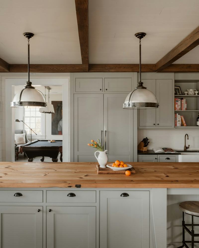 Bright farmhouse kitchen with three pendant lights over a wood island